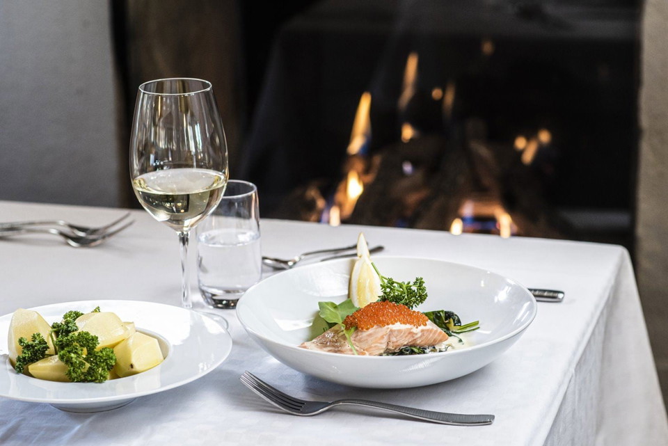 En tallrik mat och ett glas vin på ett bord.