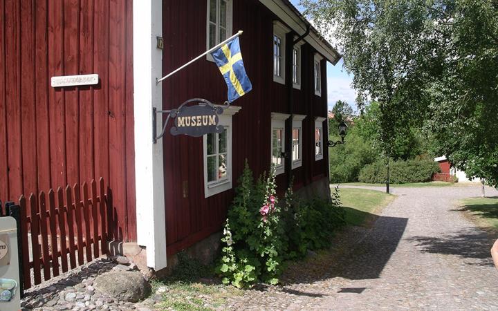 Röd träbyggnad i två våningar som inrymmer museum