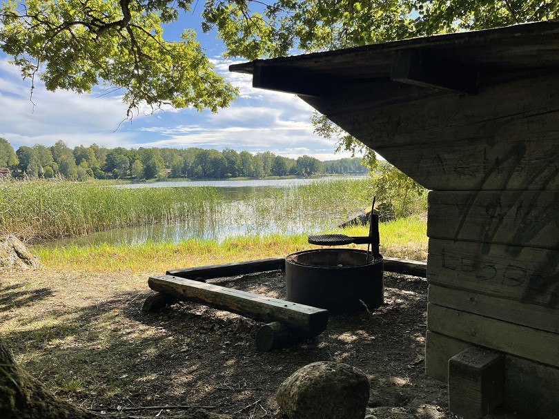 Vindskydd med grillplats framför en sjö