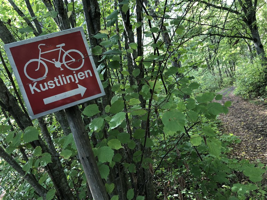 En skylt med en cykel med texten 'Kustlinjen'.