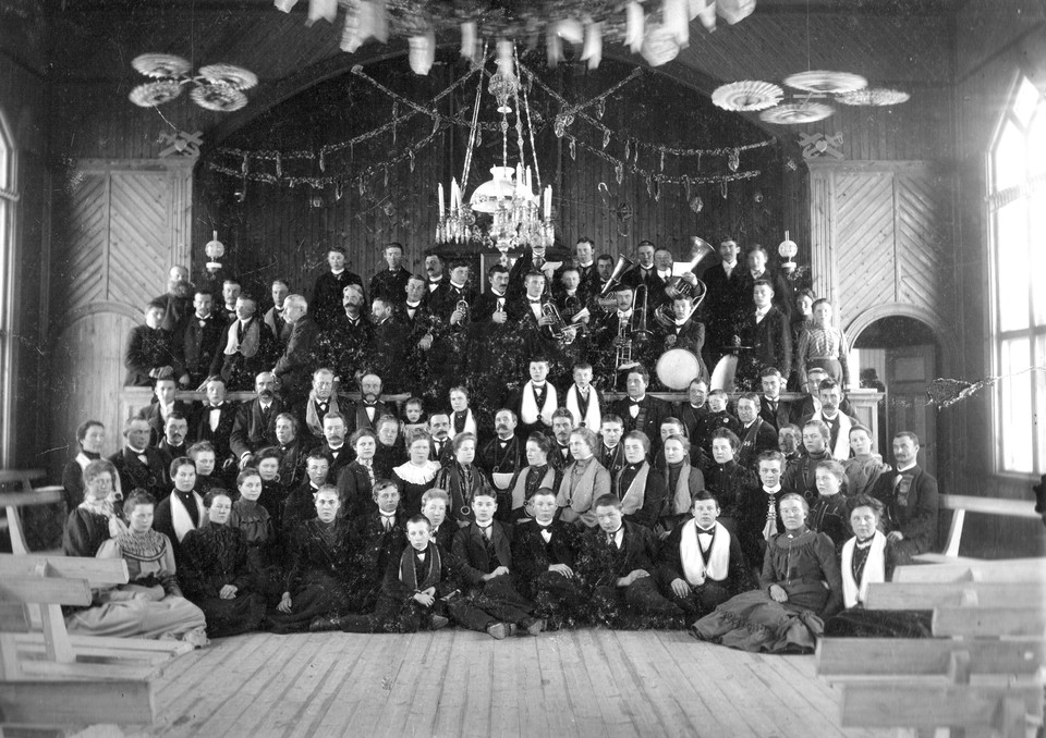  Söderhamns tidning går det att läsa om invigningen som hölls den 16 oktober 1904. En pampig invigning med många besökare från hela landet med parad och musikkår i byn Långhed. Här ett fotografi inifrån där både musiker och medlemmar ses uppklädda. Väggarna har ännu ej målats.