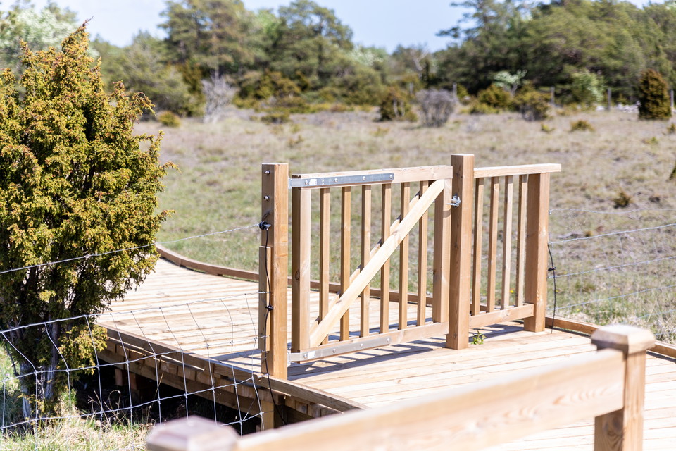 Grind i trä vid bred spång.