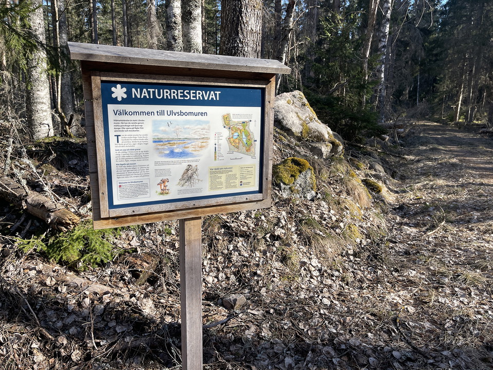 Informationsskylt på ett träställ.