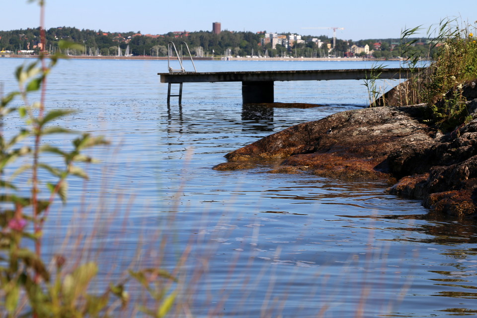 Badplats vid klippor och brygga.