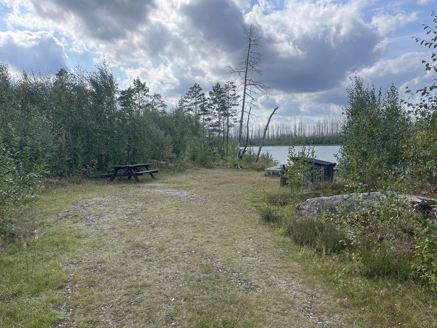 Rastplats med picknickbänk och eldstad.