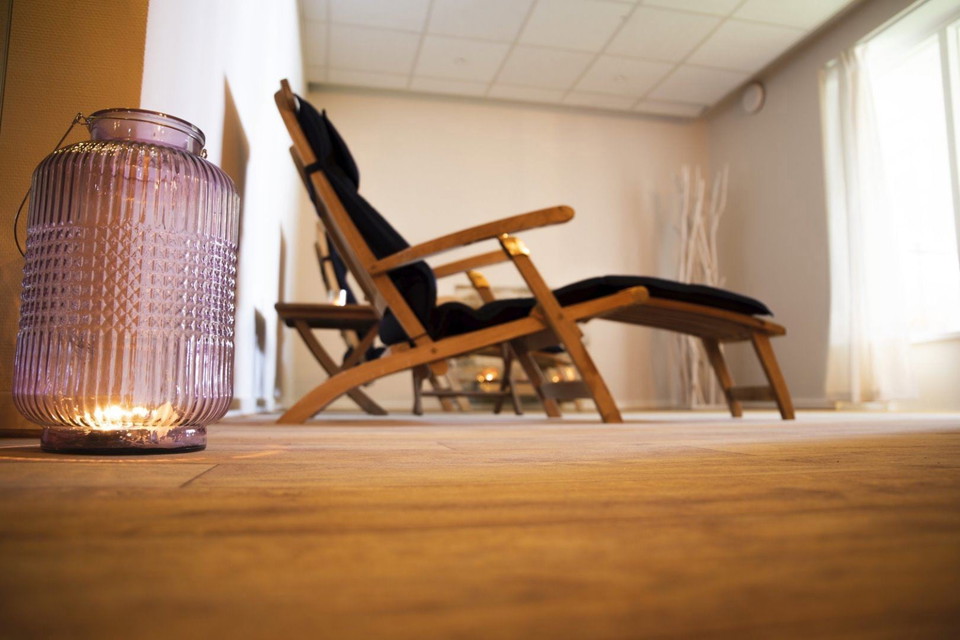 En glasvas framför en stol.