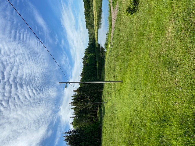 Eljusspåret i öppen terräng med klippt gräs och med våtmarker i bakgrunden