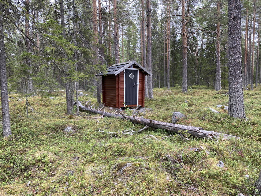 Ett rött dass i skogen.