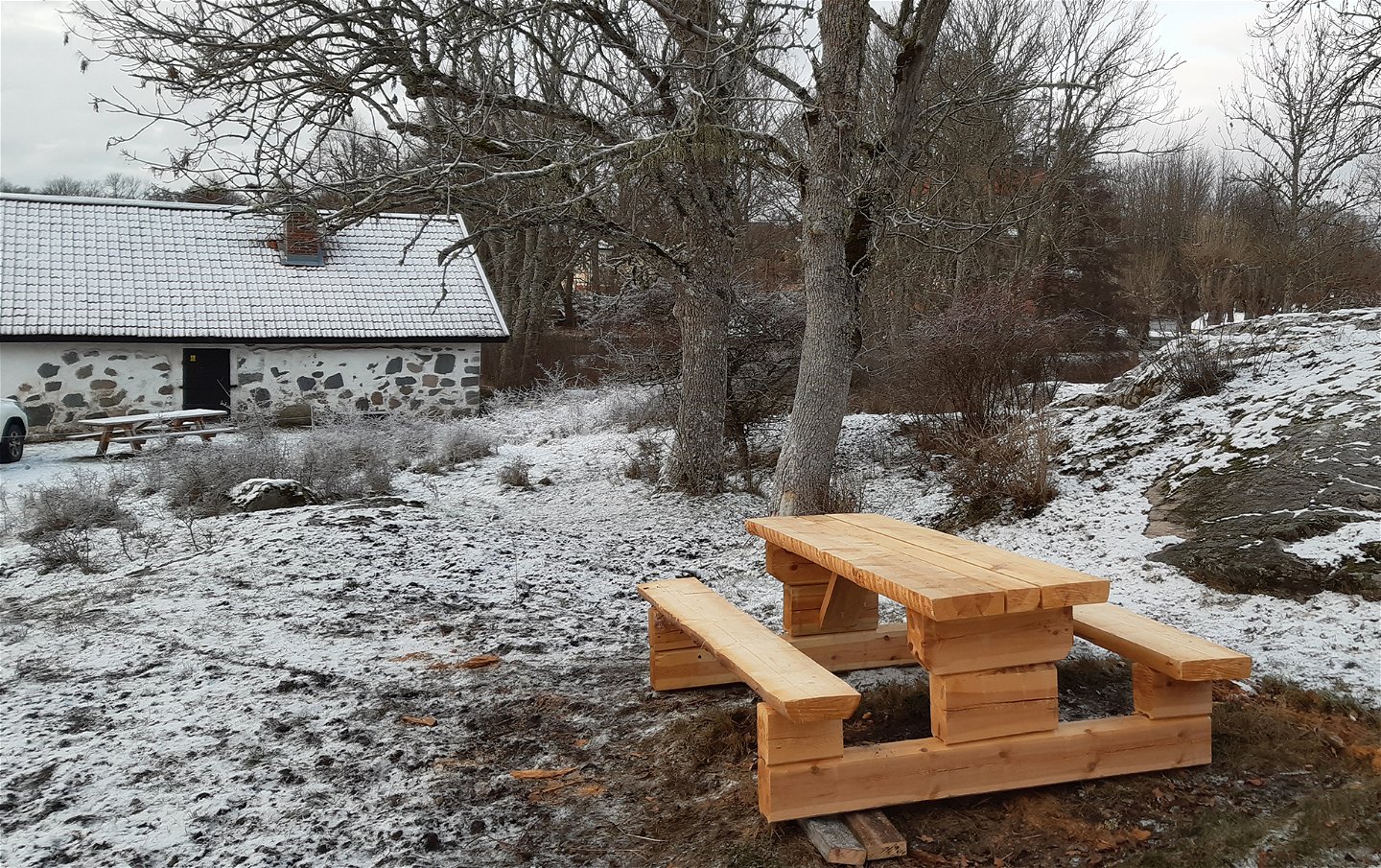 Ett nytt picknickbord med bänkar i ett vintrigt landskap.