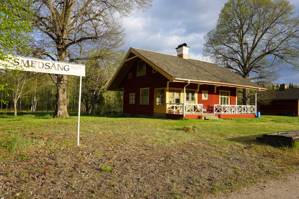 Ett gammalt stationshus med en del av perrongen och skylt längs med Salabanan