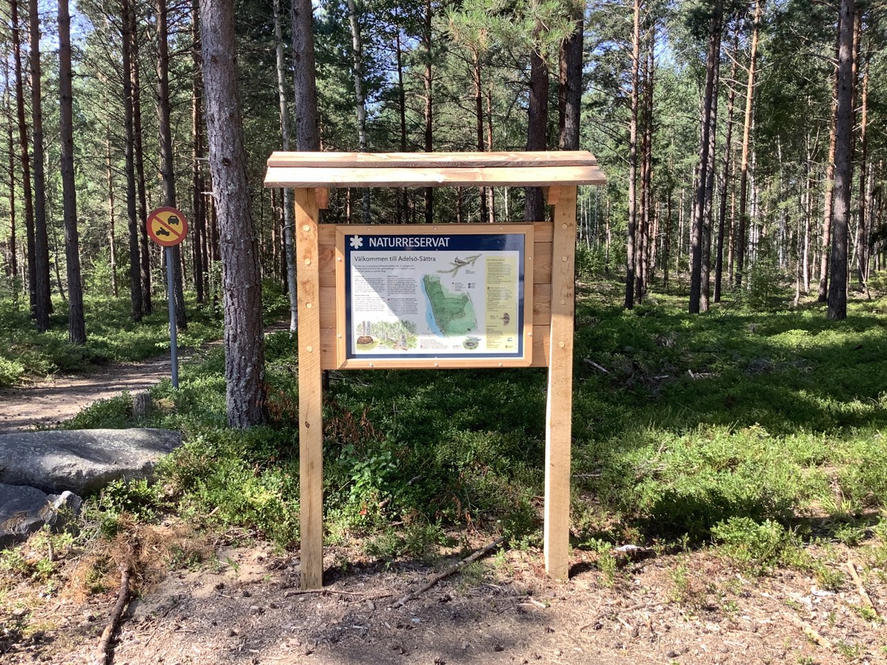 A sign provides information about the Adelsö-Sättra nature reserve.