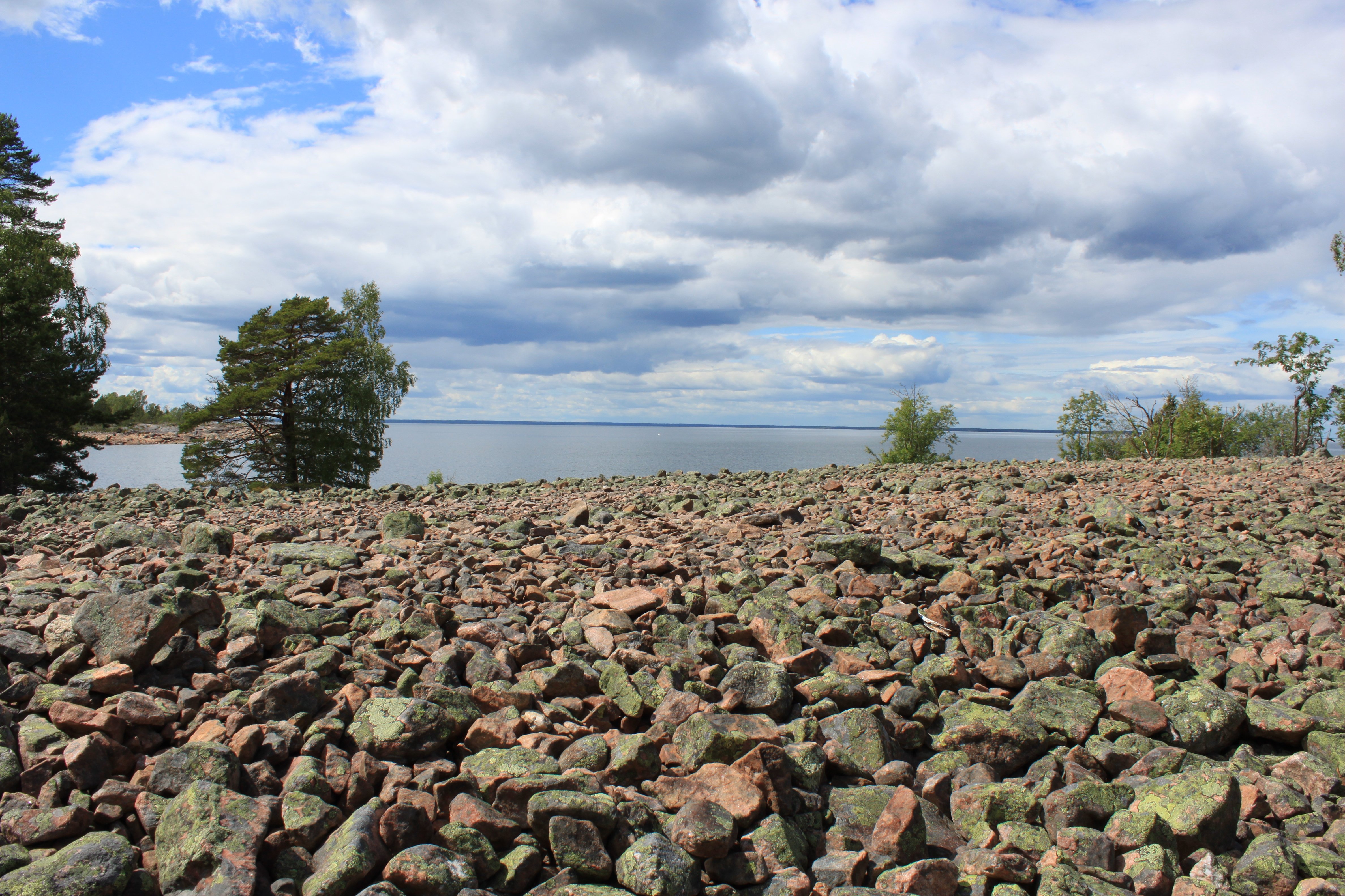 En plan öppen yta vid havet. Ytan är täckt av stenar i olika storlekar.