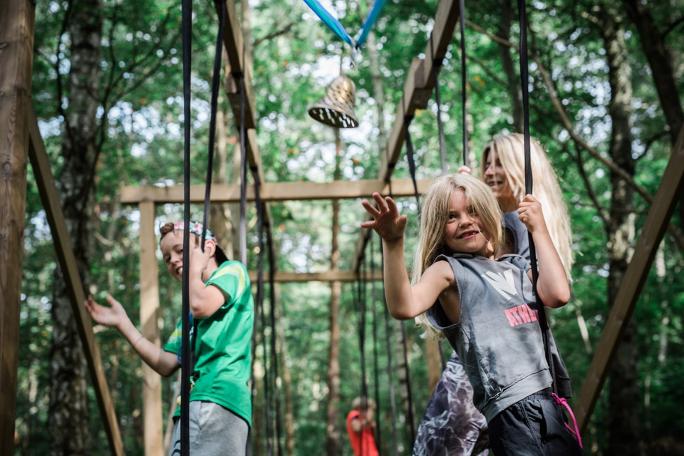 Barn som leker på en klätterställning i skogen