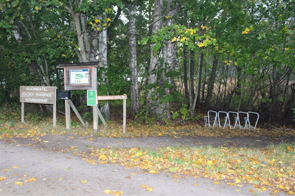 Informationstavlor och cykelställ vid parkeringen.