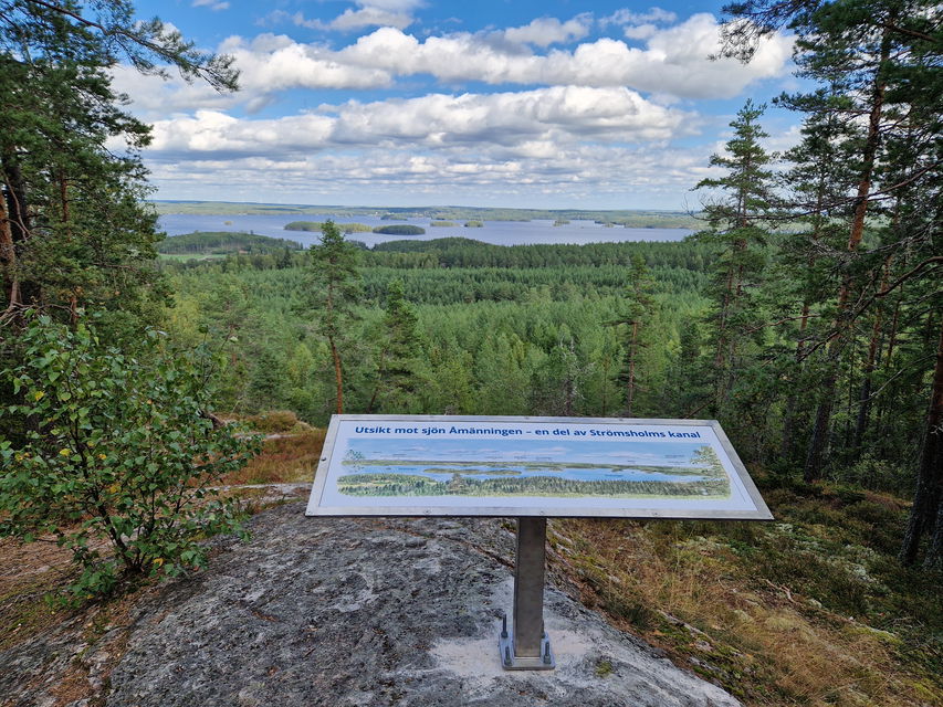 Bild på en skylt med utsiken över sjön Åmänningen i fonden.