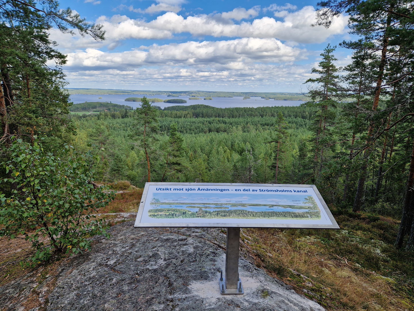 Bild på en skylt med utsiken över sjön Åmänningen i fonden.