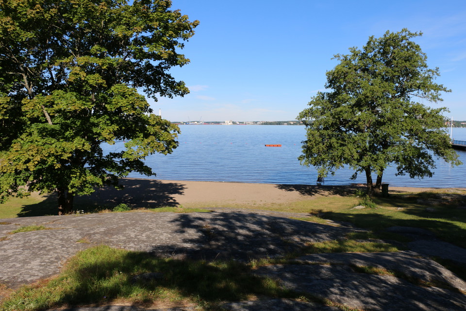 Sandstrand och Mälaren fotat från en klippa intill stranden.
