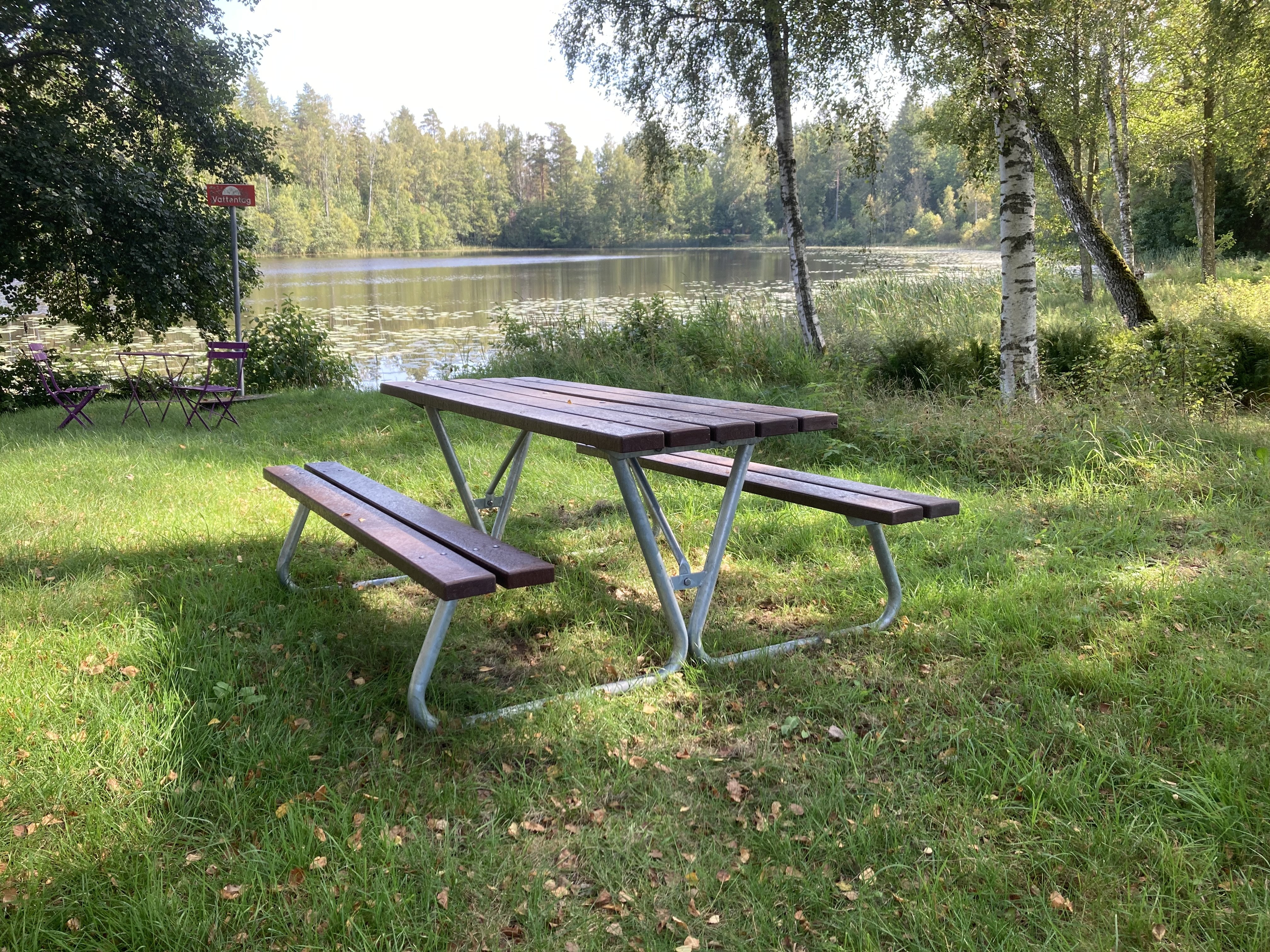 Ett bänkbord står framför en sjö