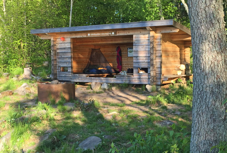 Knuttimrat vindskydd. I vindskyddet ligger sovsäckar och ett myggnät hänger från innertaket.