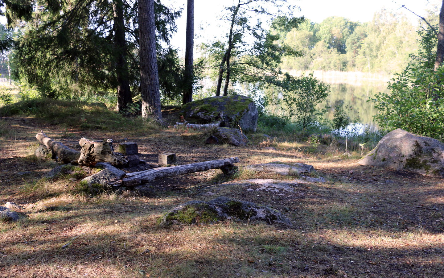 En liten eldstad och några bänkar att sitta på vid strandkanten.
