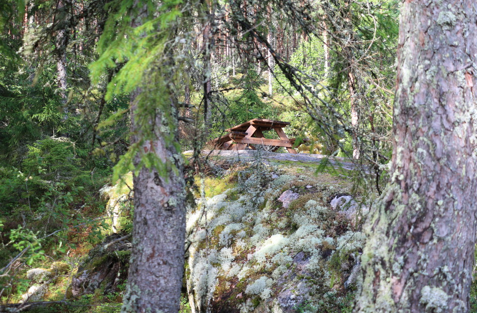 Picknickbord med bänkar på en hög klippa.