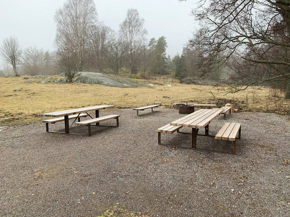 Den illgänglighetsanpassade rastplatsstora rastbord, tre bänkar, en eldstad samt vedklyv.en i Sandemar har två 