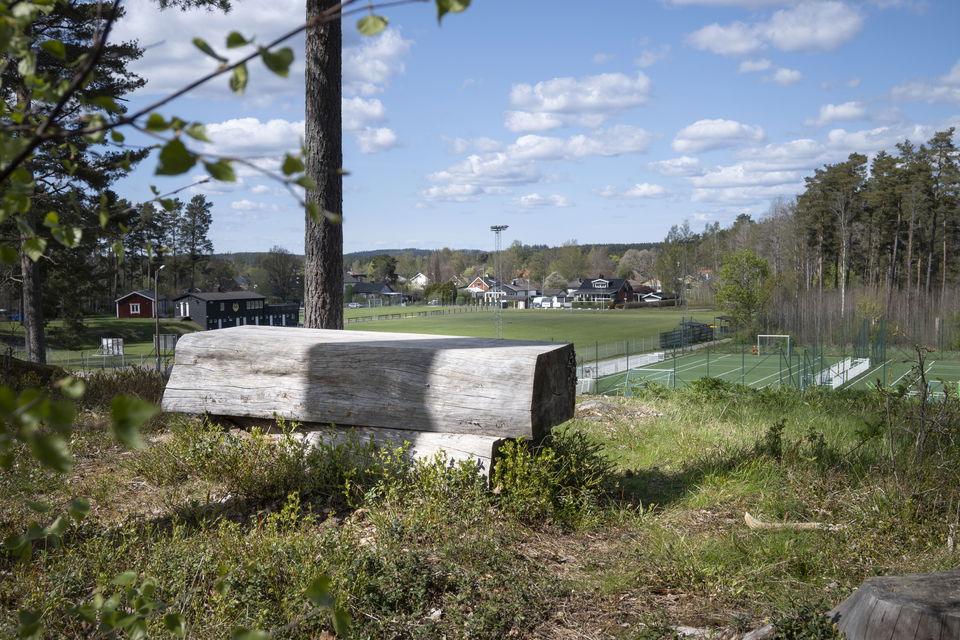 Bänk på kulle med utsikt över aktivitetsplaner och hinderbana vid Vrigstads idrottsförening.