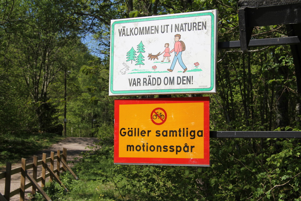 Skyltar som säger att det är cykelförbud i motionsspåren och att man ska vara rädd om naturen.
