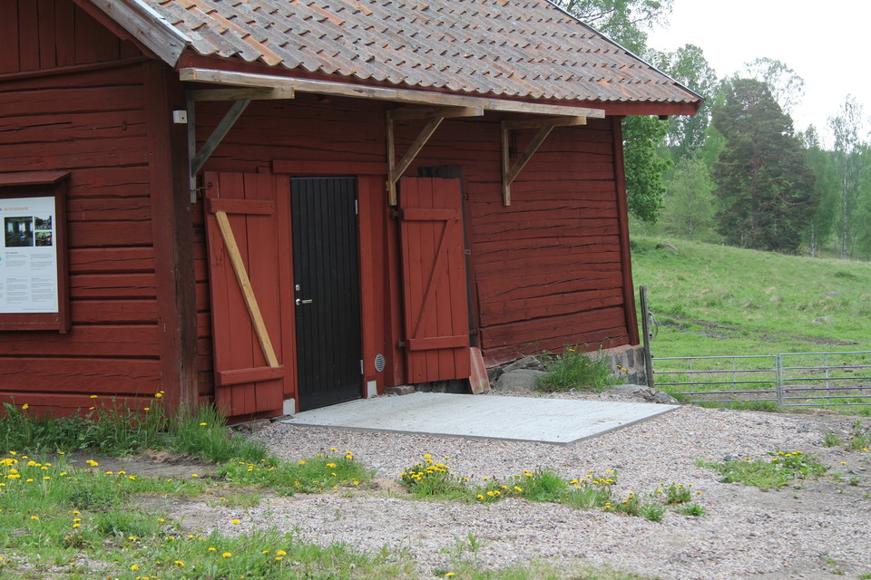 Toalett i röd byggnad. Toaletten är handikappanpassad.