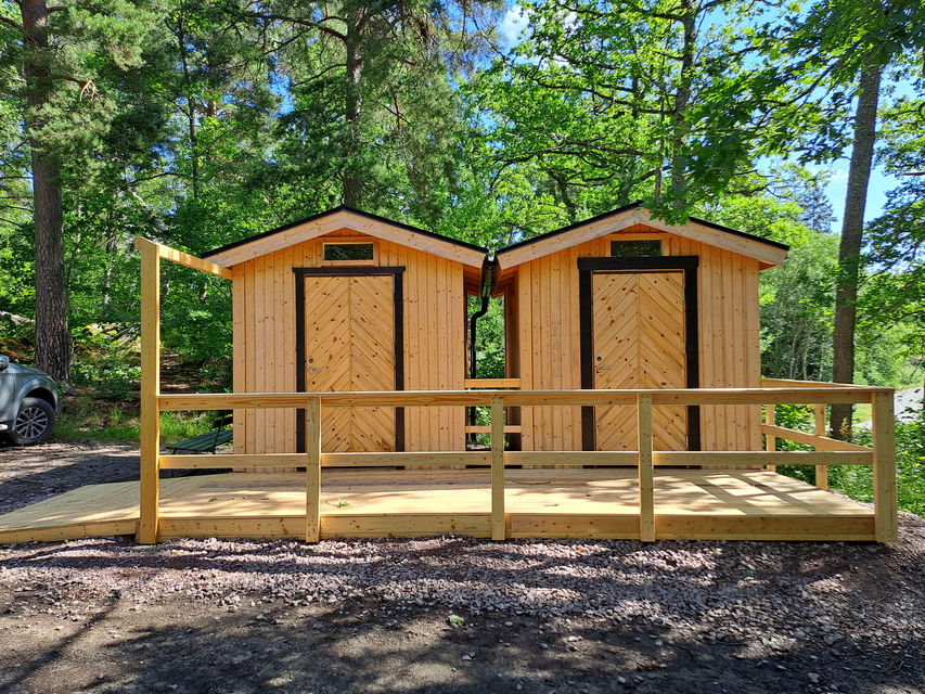 Två handikapp-, tillgänglighetsanpassade toaletter vid parkeringen.