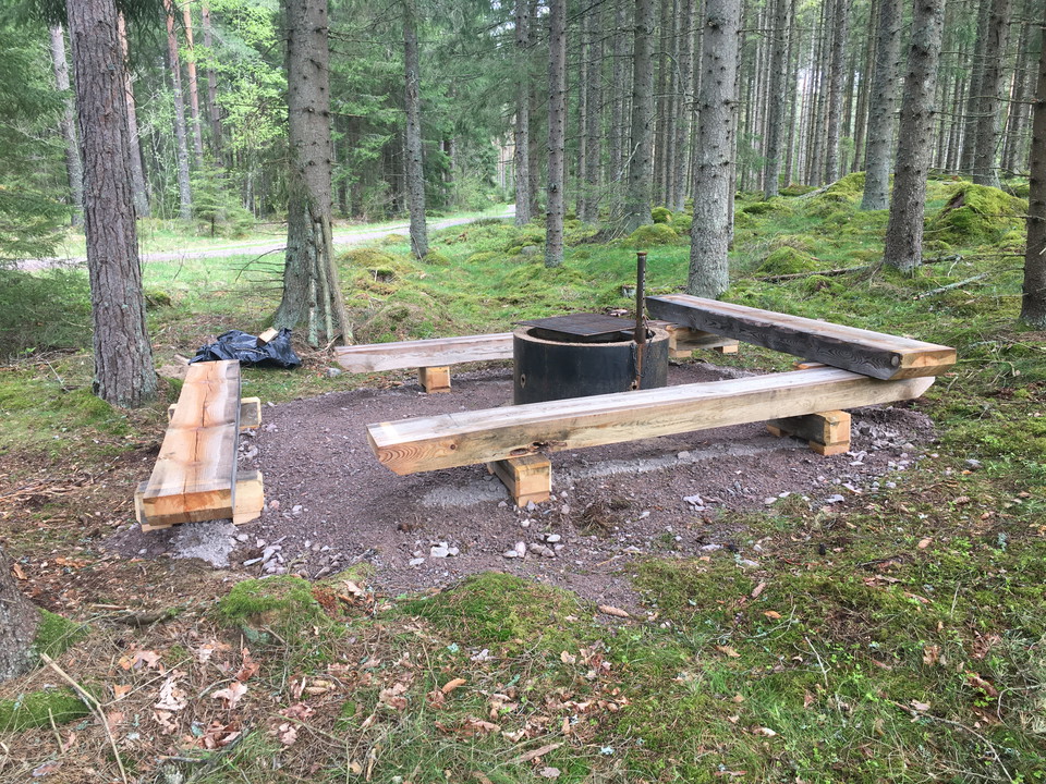 Eldplats med fyra sittbänkar runt eldplatsen