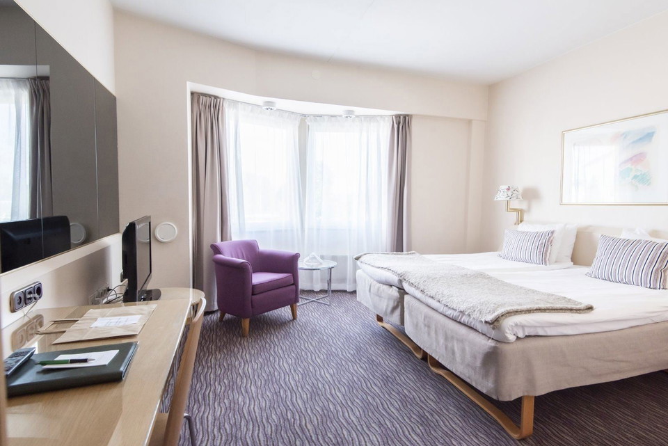 Ett rum med en säng och en lila stol.