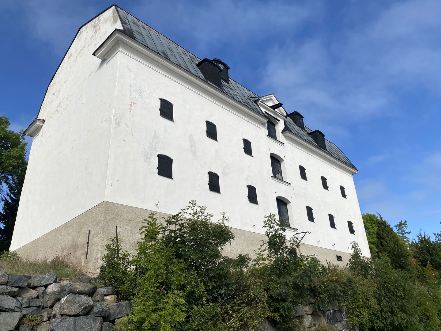 Järnmagasin med vitputsad fasad