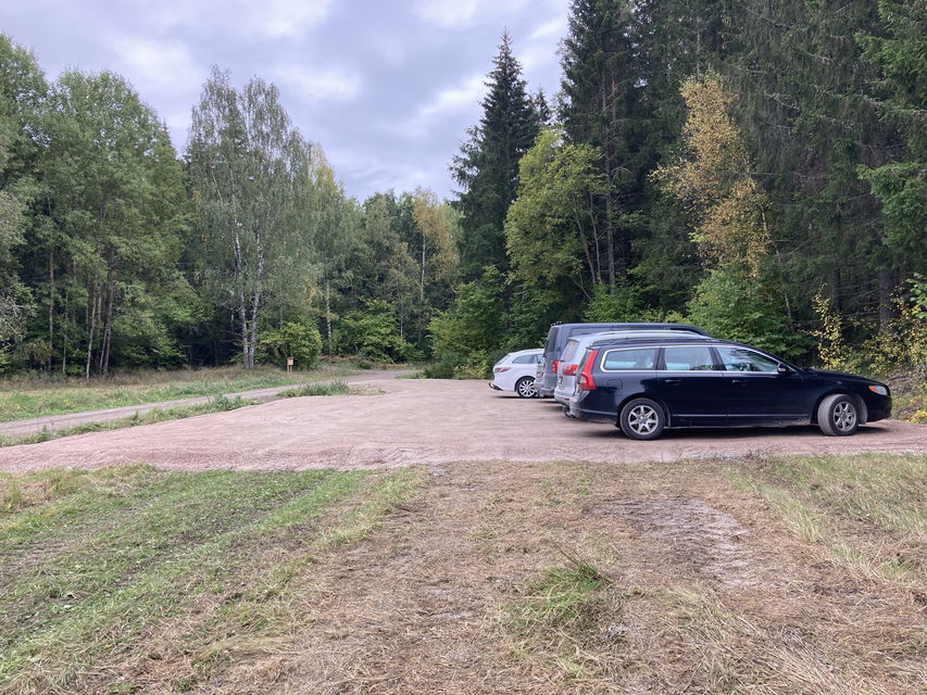 En plan grusad yta. Till höger står fem bilar parkerade sida vid sida.