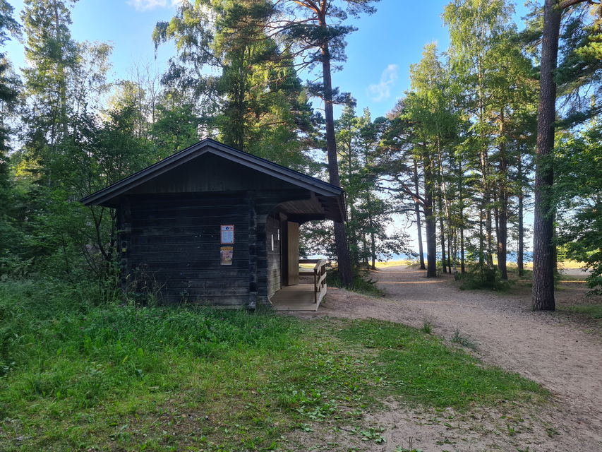 Ett mörkbrunt timrat hus. På framsidan finns en gångramp.