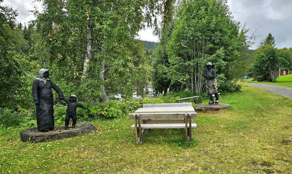 Statyer i lummig grönska med picknicbord i anslutning