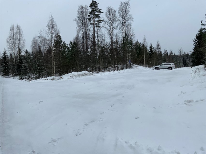En snöig parkering med en vit bil parkerad