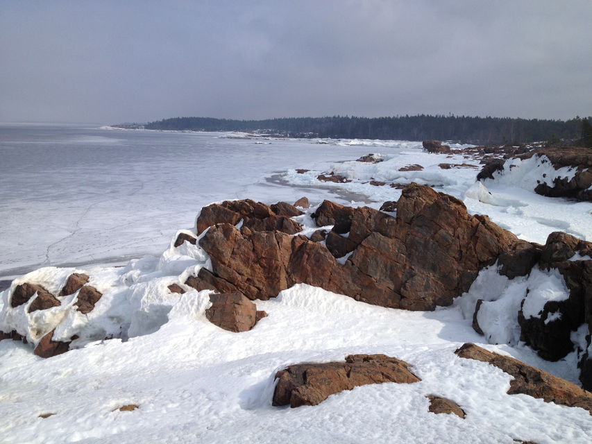 Snötäckta klippor vid havet.