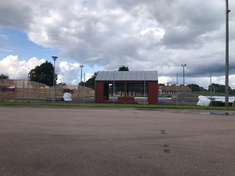 Ett vindskydd står framför en arena där du många sporter kan utövas.