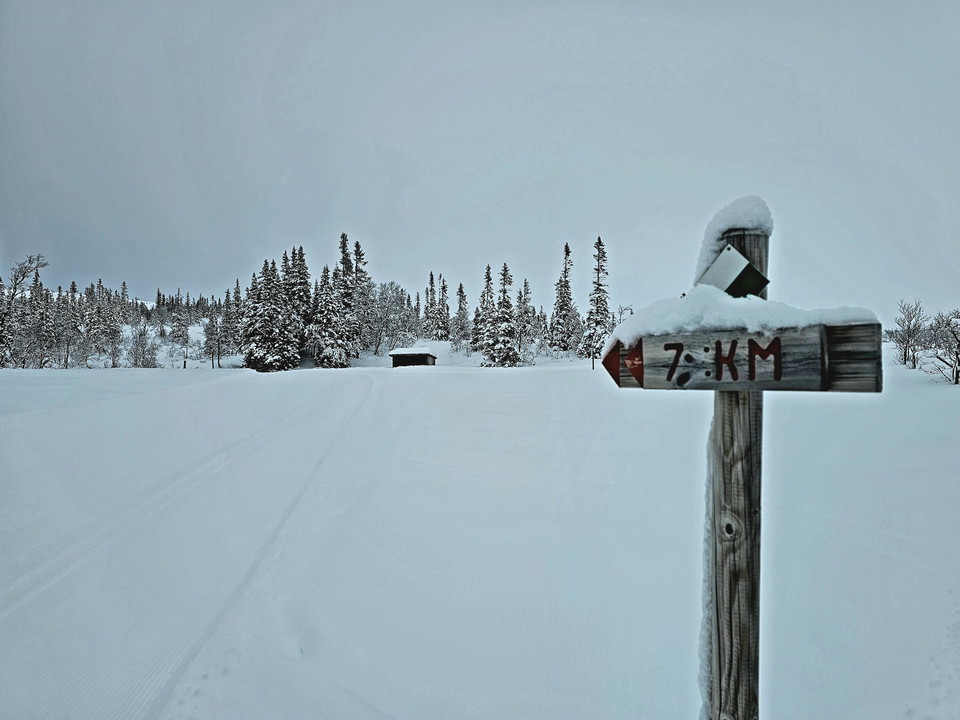 Träskylt med röd pil mot 7,5 km skidspår
