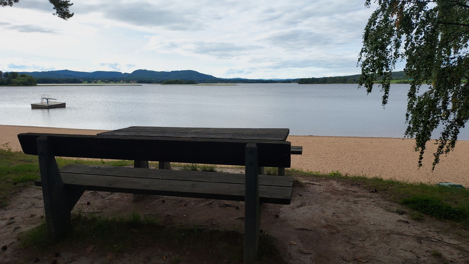 Många bänkbord ovanför stranden vid Norebadet