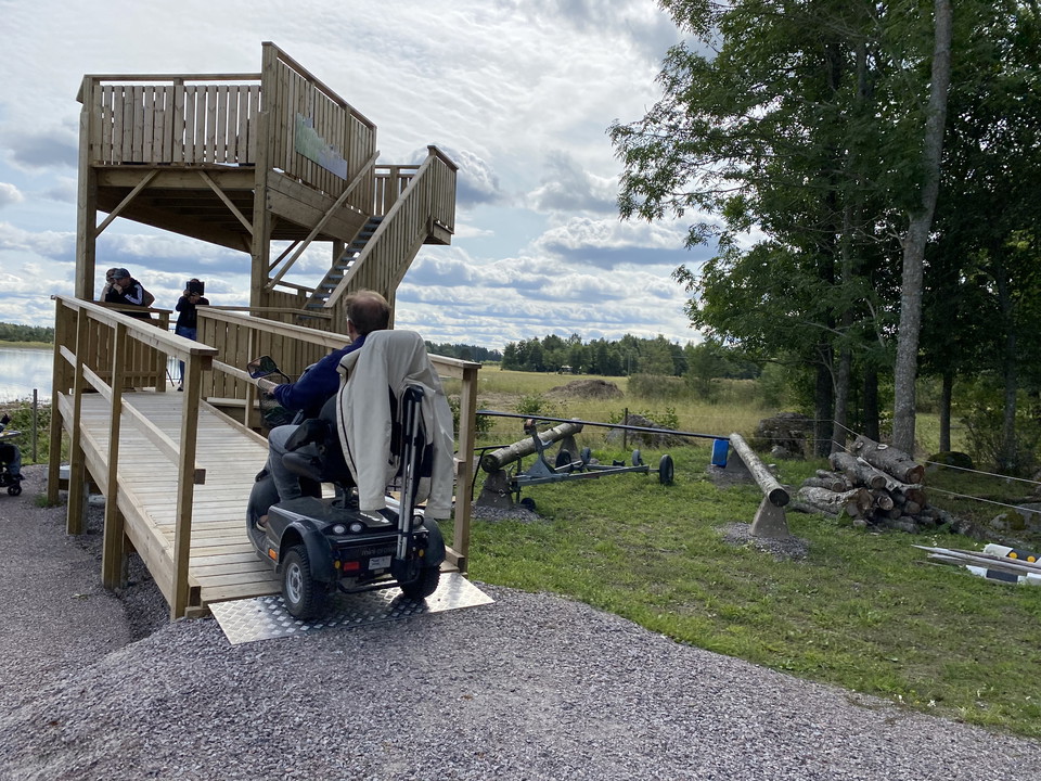 En person i elrullstol kör på rampen mot tornet.
