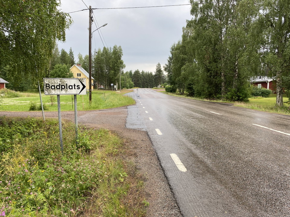 Skylt vid vägen som pekar in mot badplatsen
