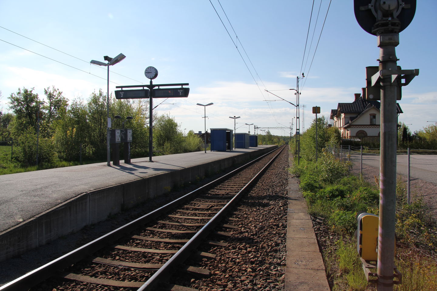 Tågstation med räls och perrong.