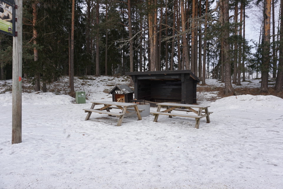 Vindskydd, två bänkbord, eldstad och vedskjul