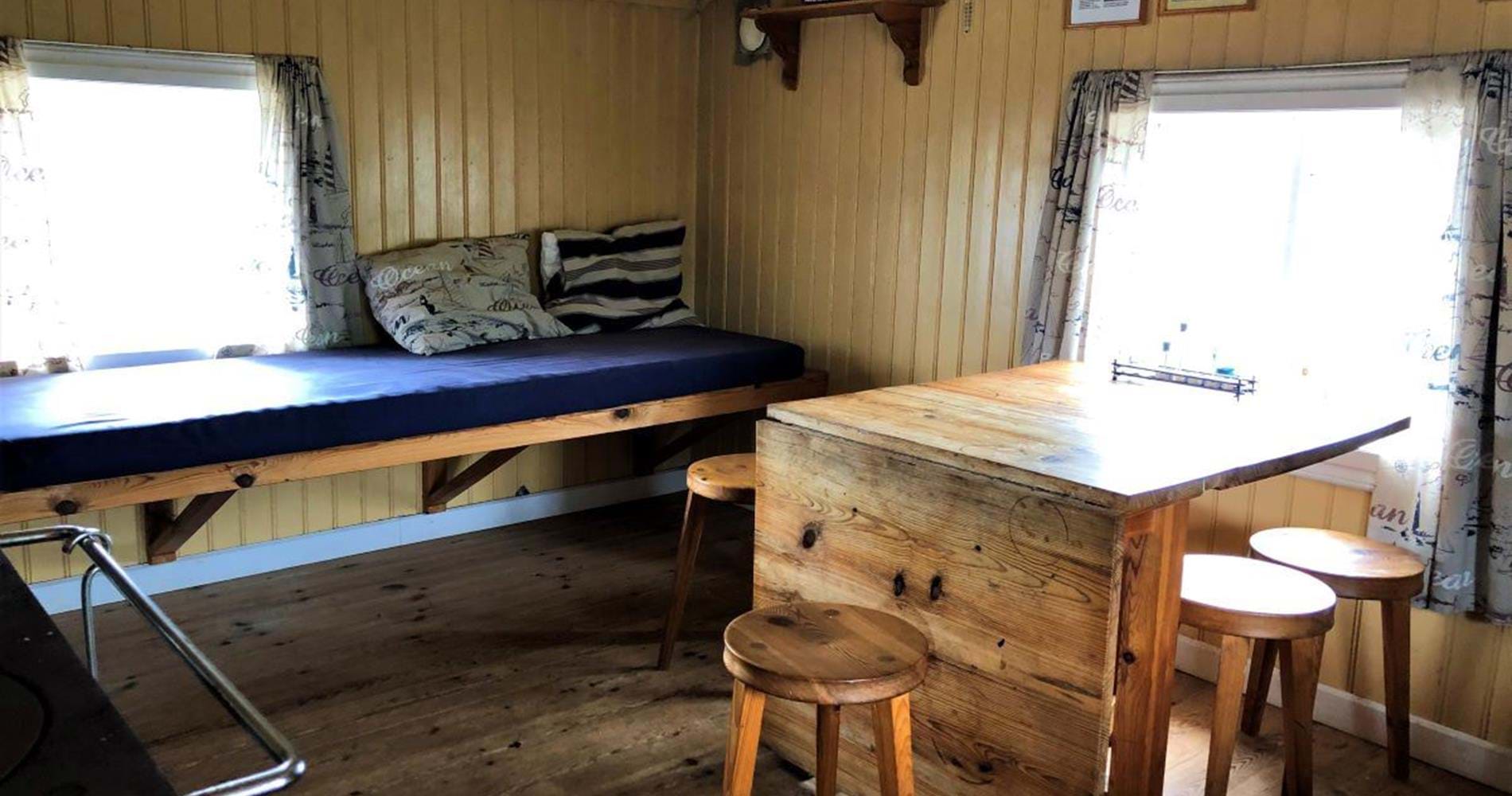 Sängplats och bord i Lotsstugan.