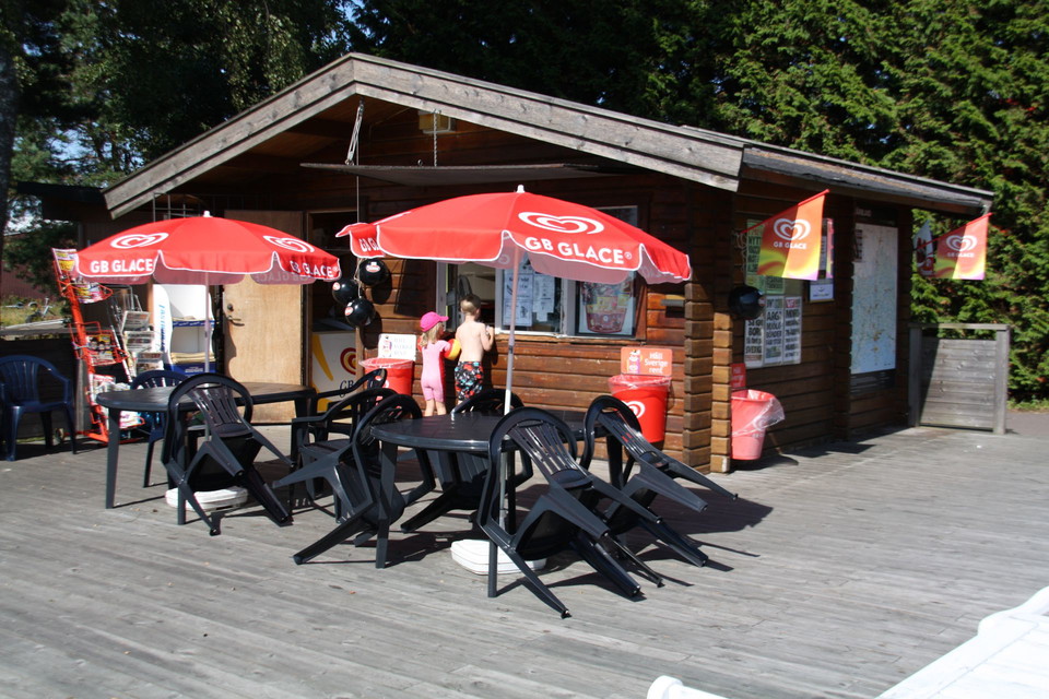 En kiosk som har bord och stolar på uteplatsen.