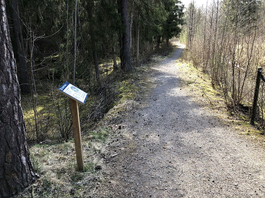Informationstavla vid grusad stig.