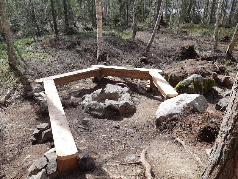 Grillplats omgiven av träbänkar i en halvcirkel