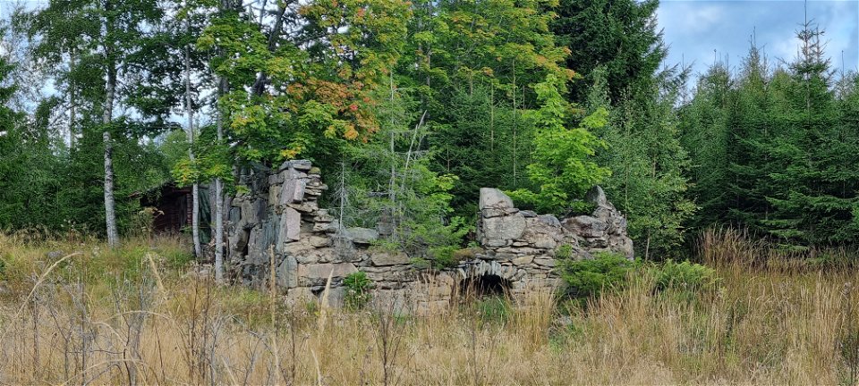 Ruin av naturstensmurad ladugård.